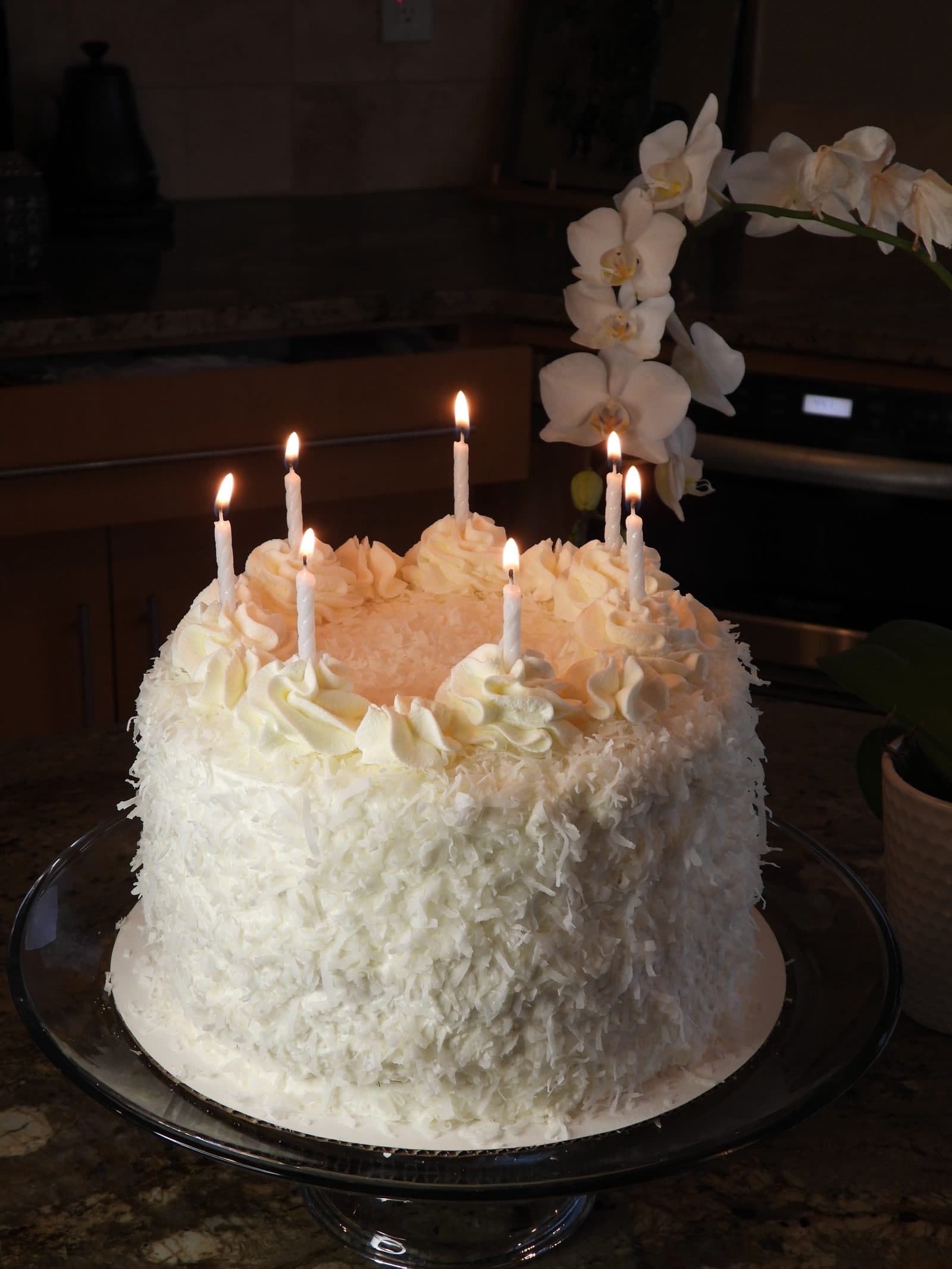 Triple coconut layer cake with lit candles